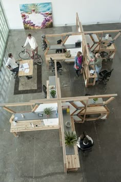 an overhead view of people sitting at desks in a room with multiple tables and chairs