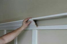 a man is painting the trim on a wall