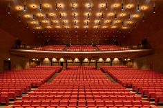 an empty auditorium with rows of red seats