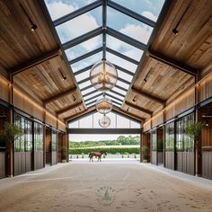 a horse is standing in the middle of an enclosed area with wood paneling and glass windows