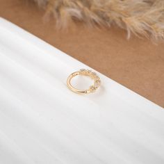 a gold ring sitting on top of a white table next to a furnishing