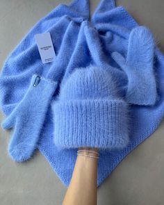 a blue blanket with a person's hand on it and a tag in the middle