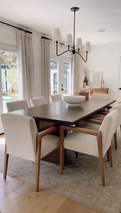 a dining room table with white chairs around it