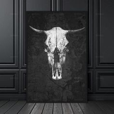 a black and white photo of a bull's skull on a wall in an empty room