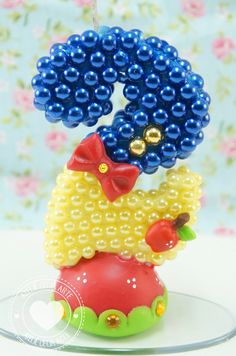 an ornament made to look like a clown with beads on it's head