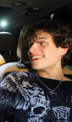 a young man sitting in the back seat of a car