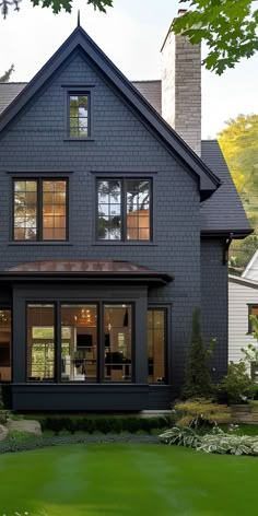 a large gray house with lots of windows on the front and side of it's roof