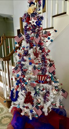 a decorated christmas tree with red, white and blue decorations on it's bottom