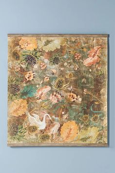 a painting hanging on the wall with flowers and birds painted on it's side