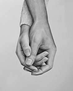 two hands holding each other while one holds the other's hand in black and white