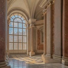 an empty room with columns and large windows