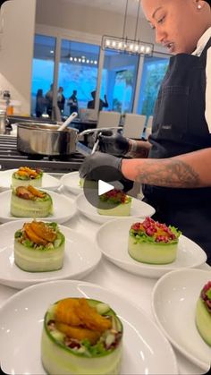 a chef preparing food on top of white plates