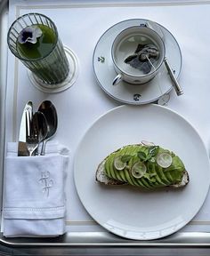 a white plate topped with an avocado cut in half on top of a table