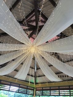 the ceiling is decorated with white drapes and lights