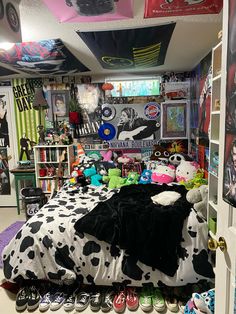 a room filled with lots of toys and stuffed animals on top of a bed covered in blankets