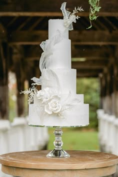 a white wedding cake sitting on top of a wooden table