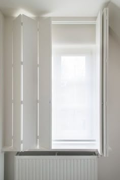 an empty room with a radiator in the corner and white paint on the walls