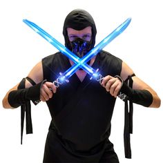 a man wearing a mask and holding two blue lightsabed swords in his hands