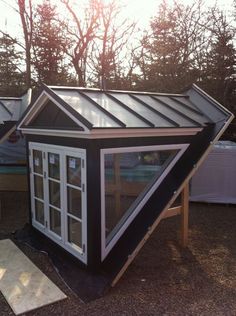 a small black and white house with a metal roof