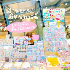 there are many items on display in the store window and behind it is a sign that says hello kitty