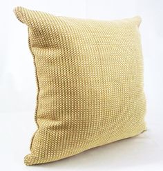 a yellow pillow sitting on top of a white table