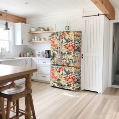 an old fashioned refrigerator is in the middle of a kitchen with white cabinets and wood floors