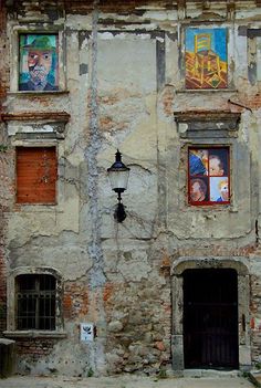 an old building with several windows and pictures on the outside wall, along with a street light