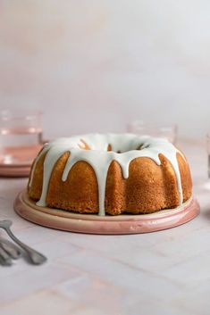 a bundt cake with white icing sitting on top of a table