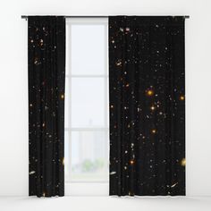 a window with black curtains and stars in the sky on it's curtain rod