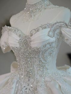 a white wedding dress with silver sequins on the bustle and shoulderline