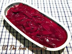 a dish filled with red liquid sitting on top of a blue and white table cloth