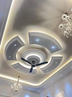 a ceiling with lights and chandeliers in a room that has white walls and ceilings