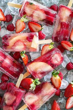 popsicles with strawberries and ice are on the table, ready to be eaten