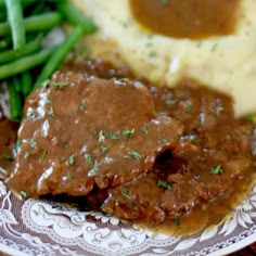 a plate with mashed potatoes, gravy and green beans