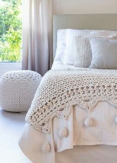 a white bed sitting in a bedroom next to a window