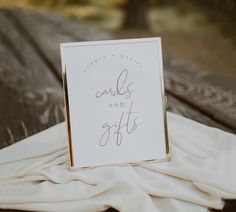 a card that is sitting on top of a table next to some cloths and a wooden bench