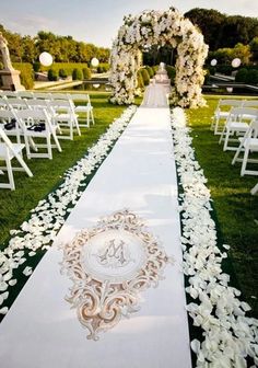 the aisle is decorated with white flowers and greenery