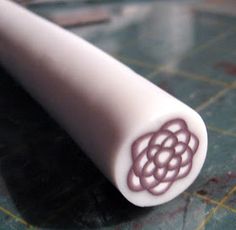 a close up of a white object on a table with some scissors in the background