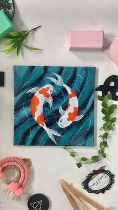 an art work with two koi fish in the middle and other items surrounding it