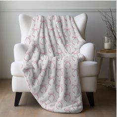 a white chair with a pink blanket on it