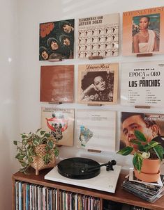 a record player sitting on top of a wooden table next to a wall filled with records