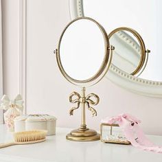 a white dresser topped with a mirror and a brush