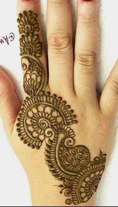 a woman's hand with henna tattoos on it, and the words written in arabic