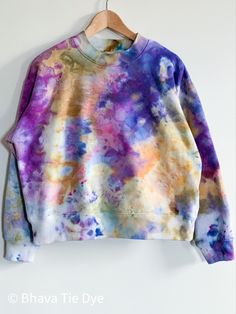 a tie dyed sweater hanging on a wall