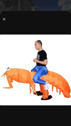 a man riding on the back of an inflatable orange horse with blue pants