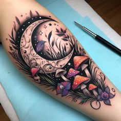 a woman's leg with a tattoo on it and the moon in the background