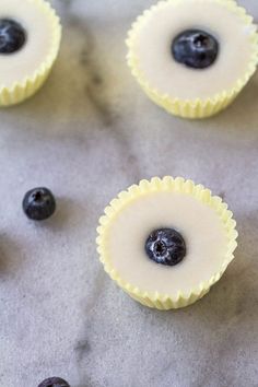 blueberry cheesecake bites on a baking sheet with fresh blueberries in the background