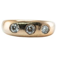 an antique three stone ring in yellow gold with two diamonds on each side and four smaller round stones at the center