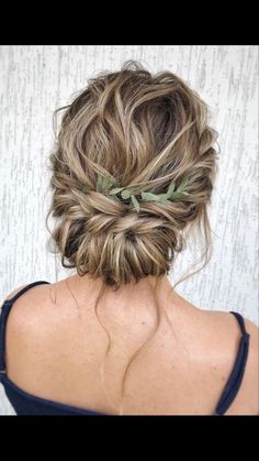 a woman with her hair in a messy bun, wearing a leafy headband