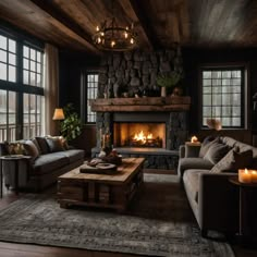 a living room filled with furniture and a fire place next to a large window covered in logs